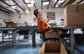 James Laskey, 40, pauses from his work and plays air guitar to piped-in music at Pioneer Center in McHenry County. Residents in the county will vote on a proposal Tuesday that would create a new property tax to support the center and other service pr