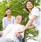 ผู้สูงอายุนั่งรถเข็นและมีคนดูแลแสดงสีน่า อารมณ์แจ่มใส