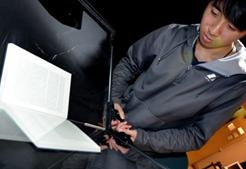 Student employee Alex Lim scans a book requested by a young scholar with a print disability, using a digitization system developed by the library. (Cathy Cockrell/NewsCenter photo)