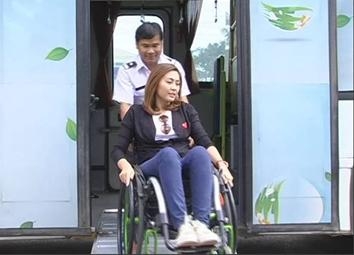 คนพิการนั่งรถเข็นใช้ทางลาดขึ้นรถเมล์