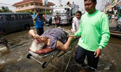ผู้สูงอายุนอนเตียงคนไข้ฝ่าน้ำท่วมไปโรงพยาบาล