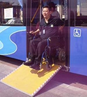 นายธีรยุทธ สุคนธวิท ผอ.ศูนย์ดำรงชีวิตอิสระคนพิการจังหวัดนนทบุรี นั่งรถเข็นคนพิการทดลองใช้ทางลาดรถเมล์ชานต่ำของรถเมล์ ขสมก.