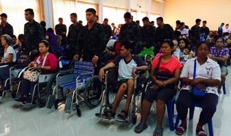 คนพิการนั่งรถเข็นเข้าร่วมพิธีมอบรถเข็นคนพิการโรงเรียนเครือข่ายการศึกษาไร้พรมแดน