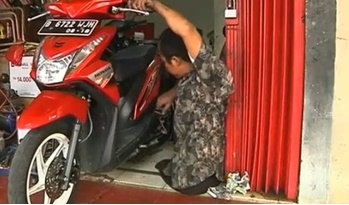 คาตูร์ บัมบัง กำลังซ่อมดัดแปลงรถมอเตอร์ไซต์สำหรับคนพิการ