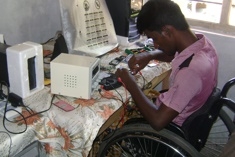 A disabled man operates a mobile phone repair business in Sri Lanka. Photo: ILO