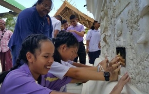 เด็กๆพิการทางสายตาสัมผัสประติมากรรมปูนปั้นนูนต่ำรอบโบสถ์วัดเขาย้อย พร้อมอักษรเบรลล์บรรยายชื่อรูป