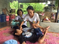 นางละมัย สกุลมาศ กำลังดูแลลูกชายพิการ อย่างใกล้ชิด