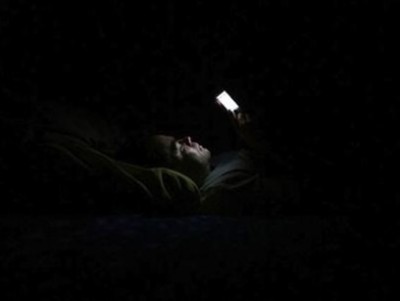 ภาพ คนนอนเล่นมือถือในที่มืด เป็นภาพตัวอย่างการใช้ โทรศัพท์มือถือในที่มืด ซึ่งแพทย์ชี้ว่าหากกระทำพฤติกรรมดังกล่าวเป็นเวลานานติดต่อกัน อาจเสี่ยงต่อภาวะจอประสาทตาเสื่อมจนนำไปสู่การตาบอดถาวรได้ (ภาพ - เอเยนซี)