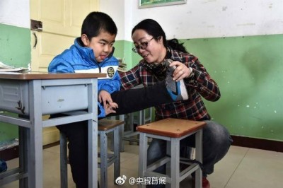 คุณครูสาวนั่่งลงที่พื้นเป็นพันๆครั้ง เพื่อดูแลเด็กนักเรียนที่พิการ ไม่สามารถลุกยืนหรือเดินเองได้